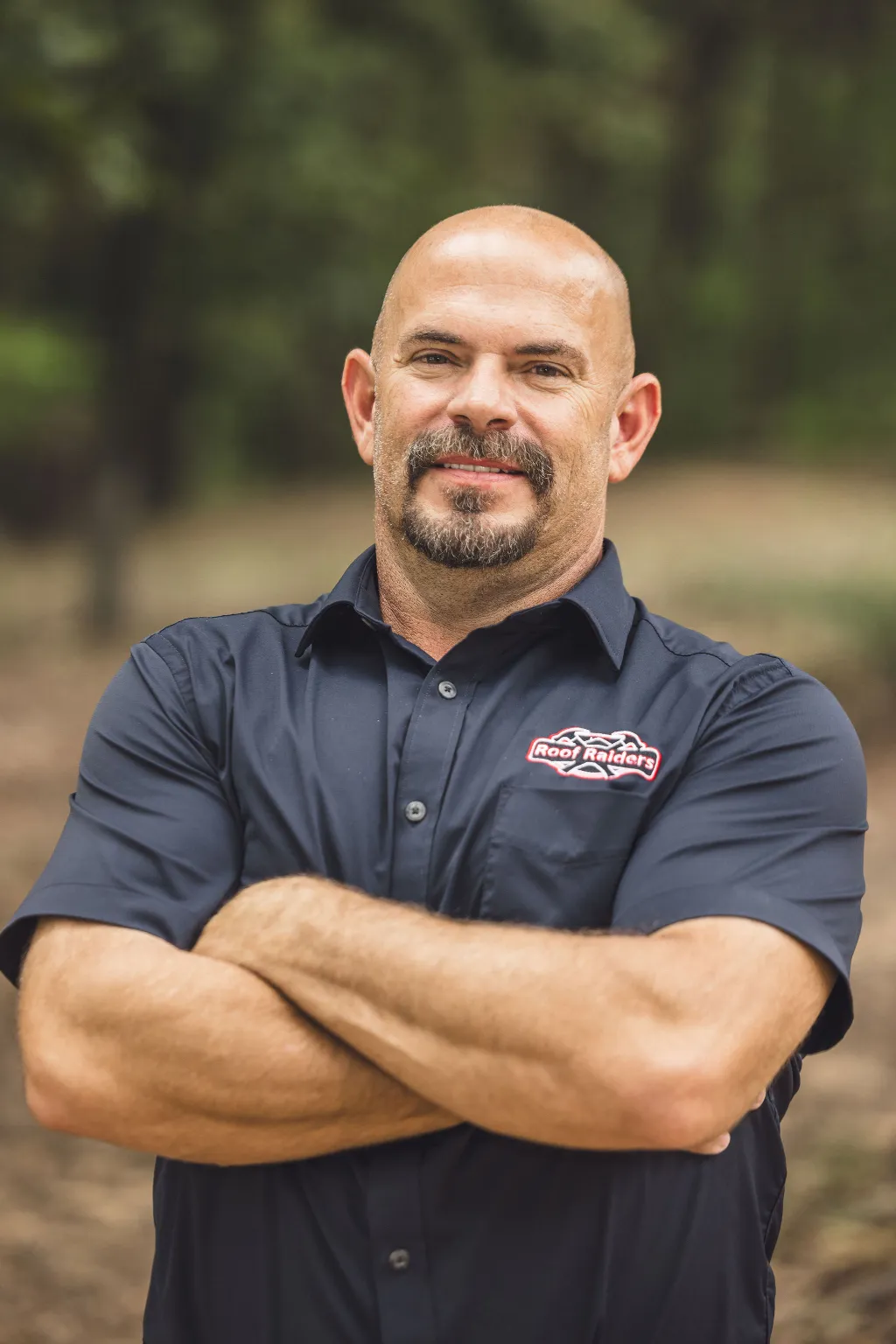Eric Moody standing and smiling with his arms crossed.
