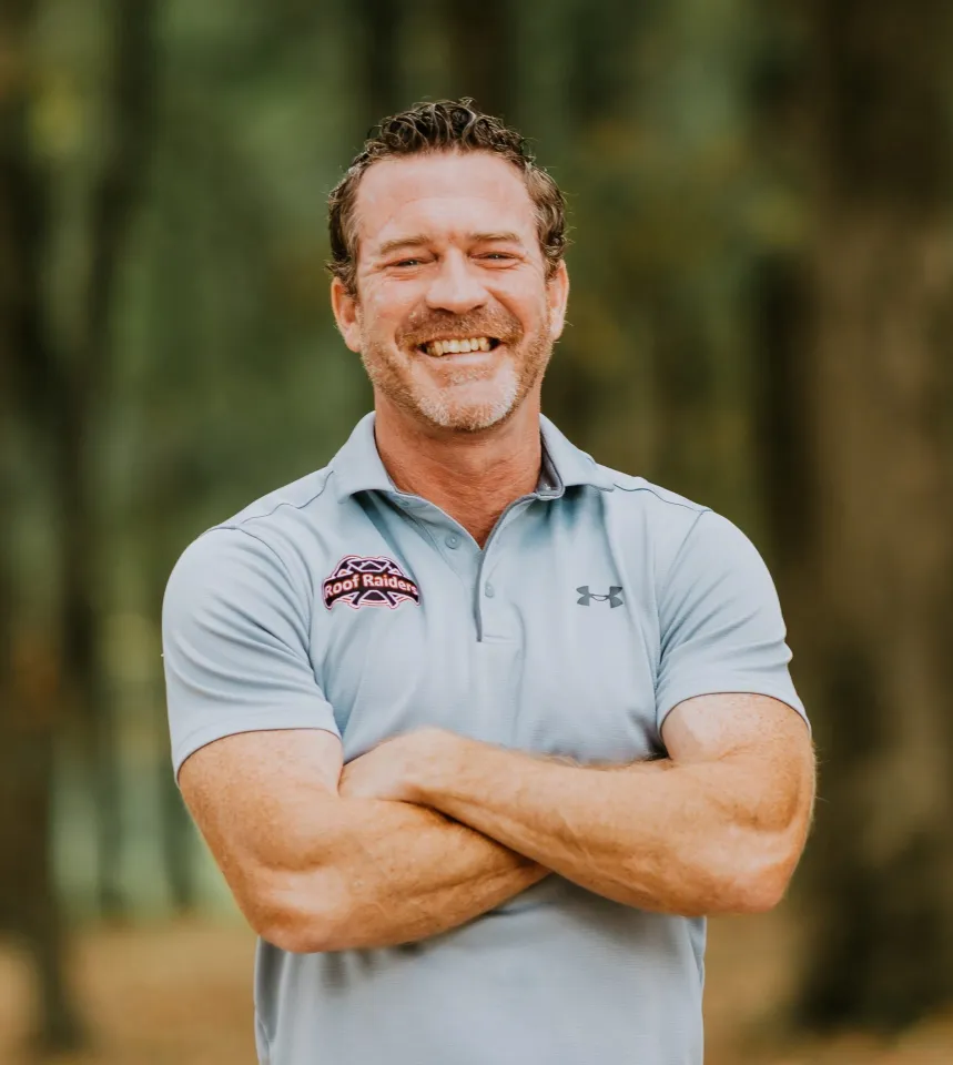 Corey Smith smiling with this arms crossed.